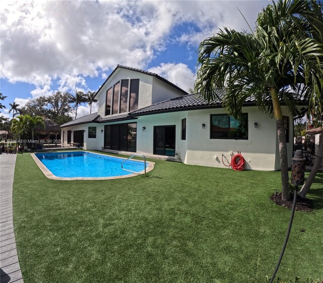 rear view of property with a yard