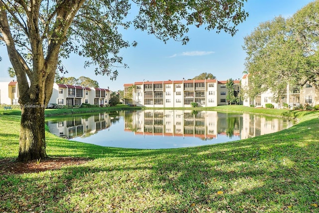 view of property's community with a water view and a lawn