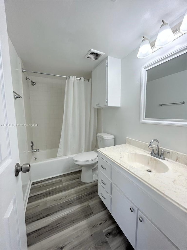 full bathroom with shower / bath combo, hardwood / wood-style flooring, vanity, and toilet