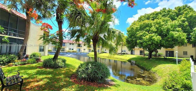 view of home's community featuring a lawn and a water view