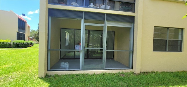 doorway to property featuring a lawn