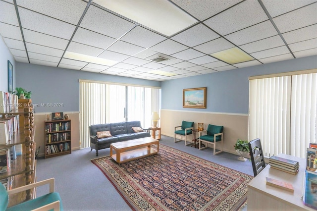 living room featuring a paneled ceiling and carpet