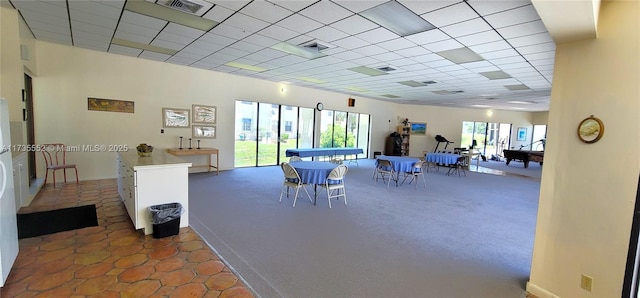 interior space featuring a paneled ceiling and dark carpet