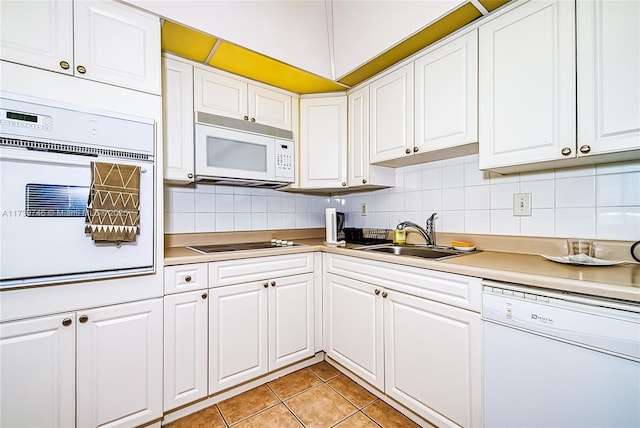 kitchen with white cabinetry, sink, and white appliances