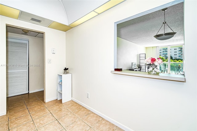 interior space with tile patterned floors and a textured ceiling