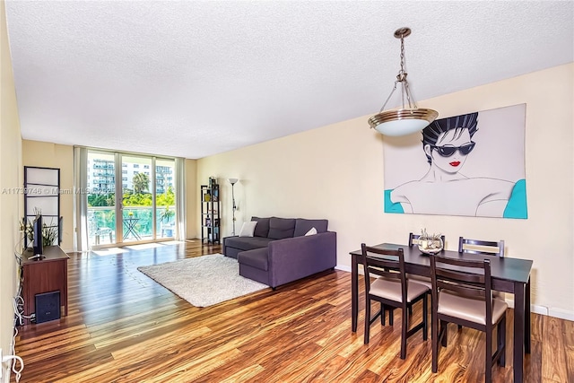 dining room with hardwood / wood-style flooring, floor to ceiling windows, and a textured ceiling