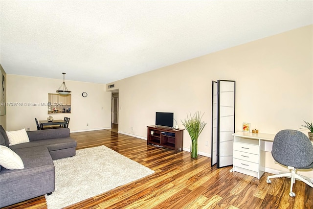 living room with wood-type flooring and a textured ceiling