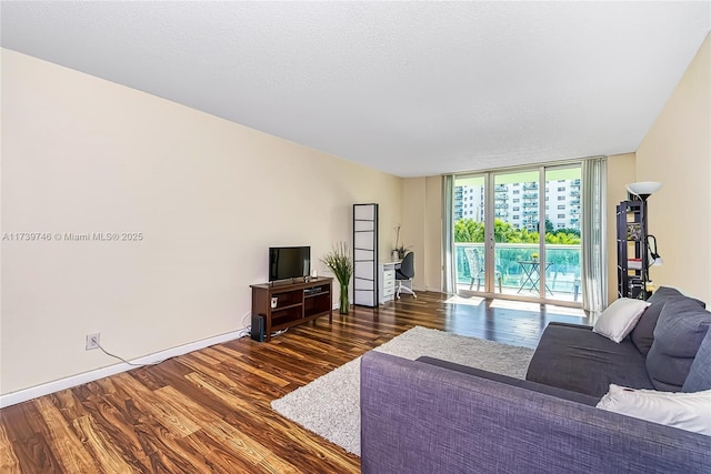 living room with floor to ceiling windows, dark hardwood / wood-style floors, and a textured ceiling