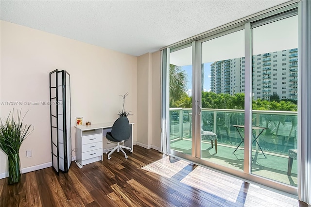 office area with a textured ceiling, dark hardwood / wood-style floors, and expansive windows