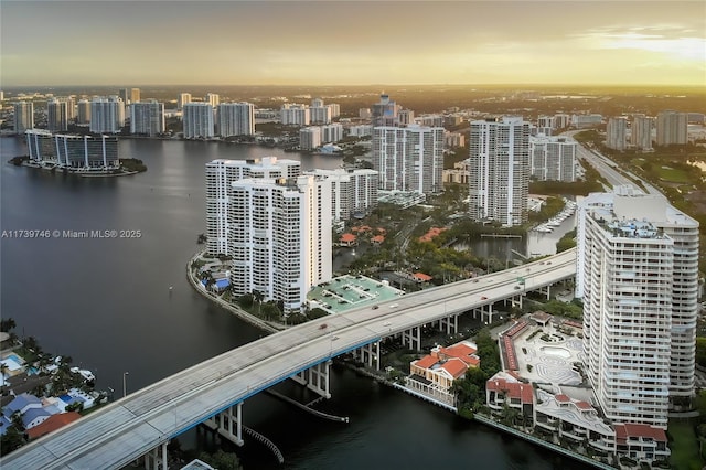 aerial view at dusk featuring a water view