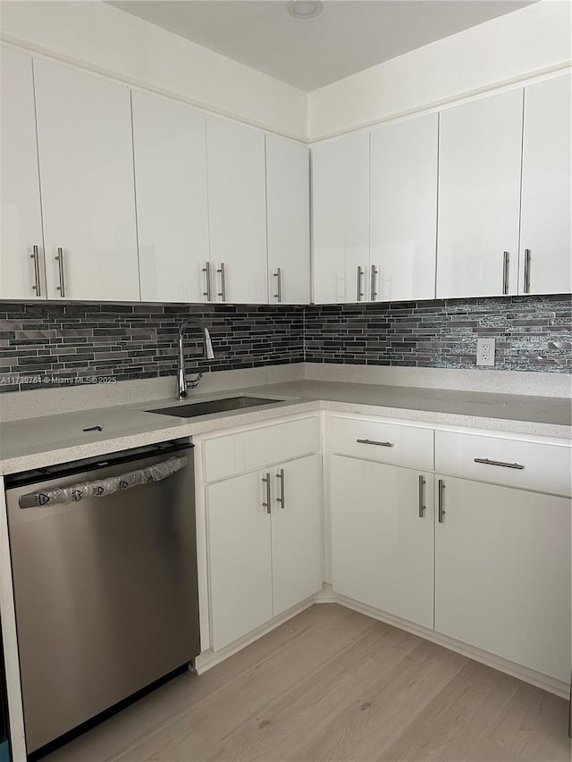 kitchen with white cabinetry, stainless steel dishwasher, and sink