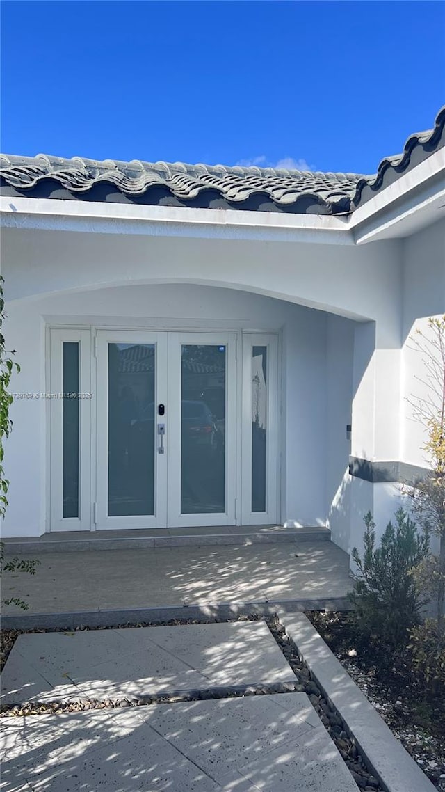 property entrance with a patio and french doors