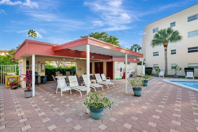 view of patio with area for grilling and a community pool