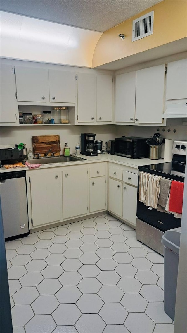 kitchen with appliances with stainless steel finishes, sink, white cabinets, and a textured ceiling