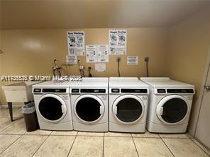 washroom with light tile patterned floors and washing machine and clothes dryer