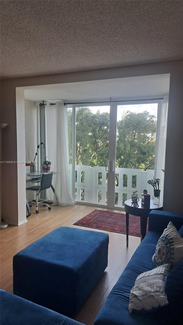 living room featuring a healthy amount of sunlight, hardwood / wood-style floors, and a textured ceiling