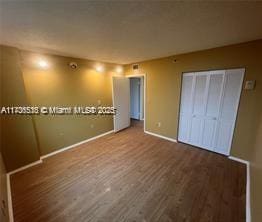 unfurnished bedroom featuring hardwood / wood-style floors and a closet