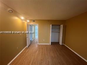 unfurnished bedroom with hardwood / wood-style flooring and a closet