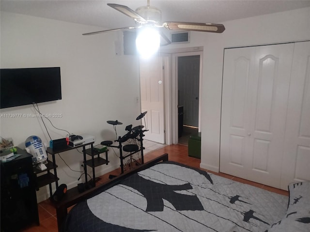 bedroom with tile patterned floors, ceiling fan, and a closet