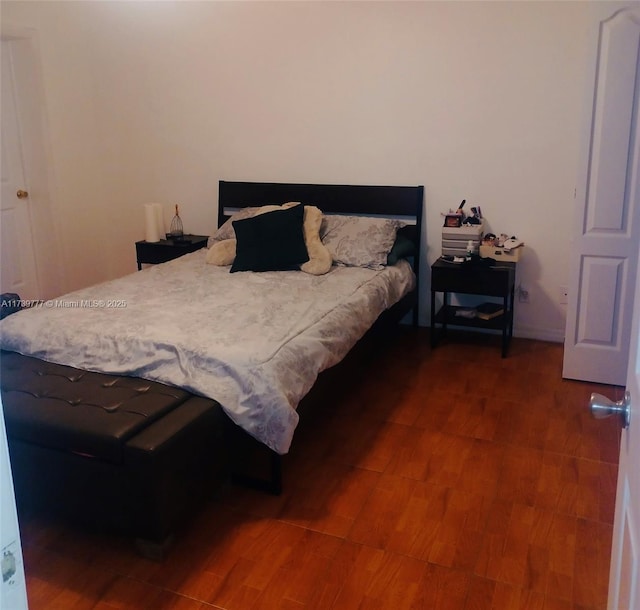 bedroom with dark hardwood / wood-style floors