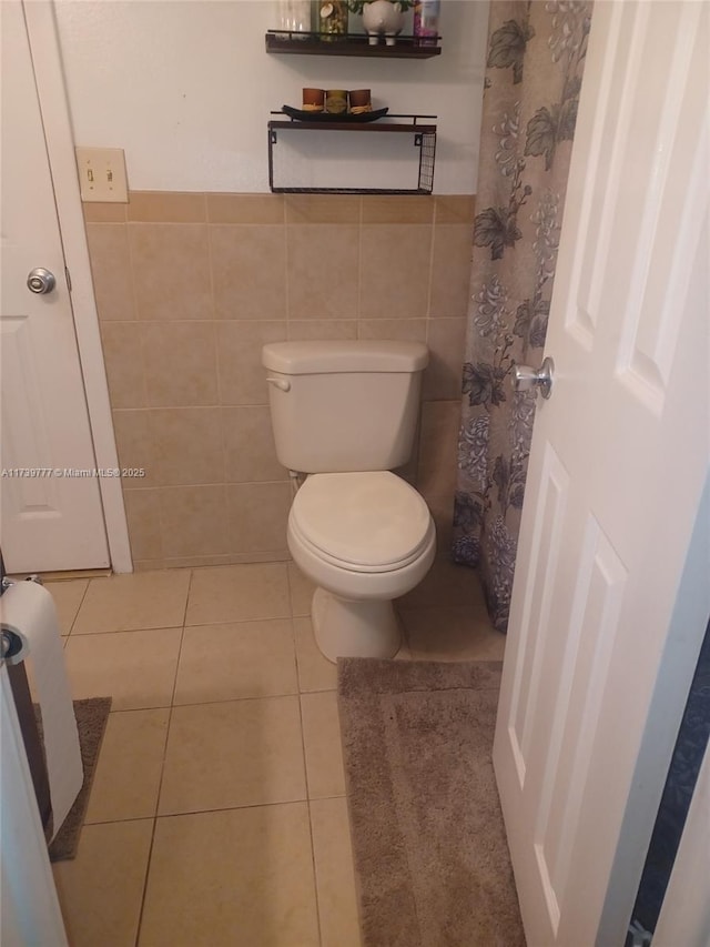 bathroom with tile patterned flooring, tile walls, and toilet