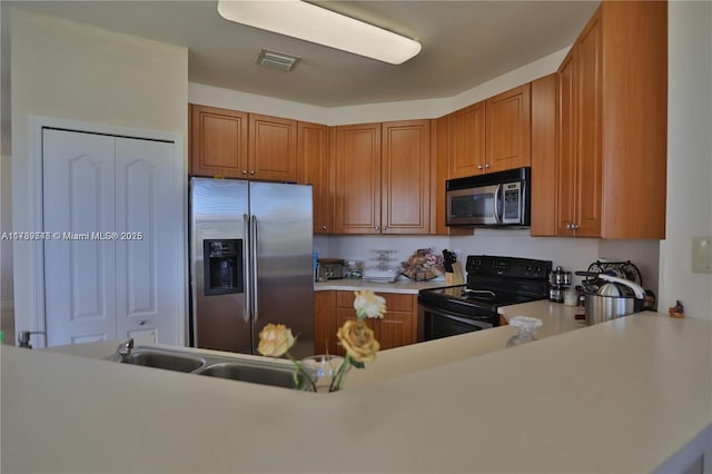 kitchen with stainless steel appliances, kitchen peninsula, and sink