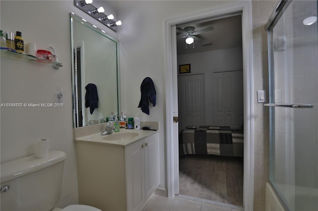 full bathroom with ceiling fan, combined bath / shower with glass door, tile patterned flooring, vanity, and toilet