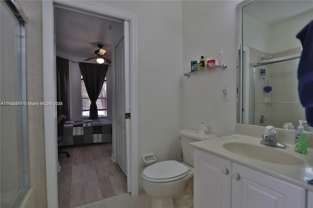 bathroom with ceiling fan, vanity, toilet, and a shower with shower door