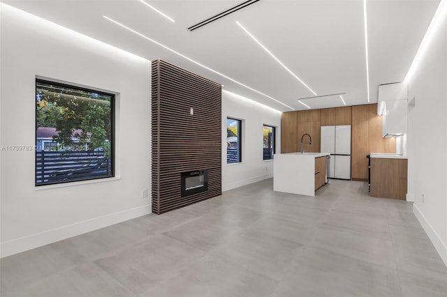 unfurnished living room with sink and a fireplace