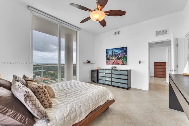 bedroom with light tile patterned floors, a wall of windows, and ceiling fan