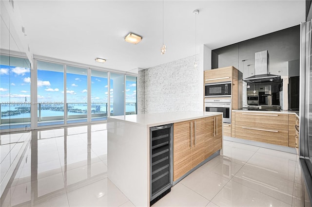 kitchen with black microwave, beverage cooler, hanging light fixtures, stainless steel oven, and a water view