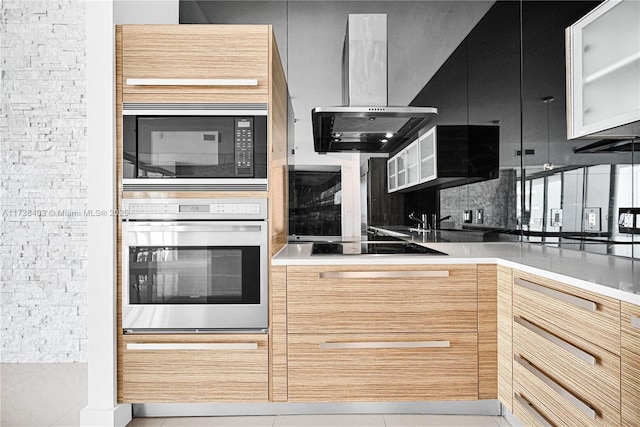 kitchen with light tile patterned flooring, light brown cabinetry, ventilation hood, and black appliances