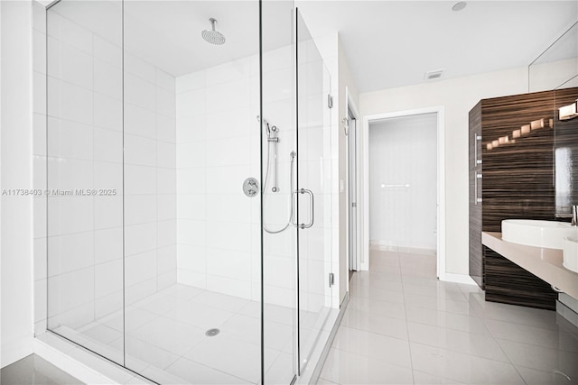 bathroom with a shower with shower door and tile patterned floors