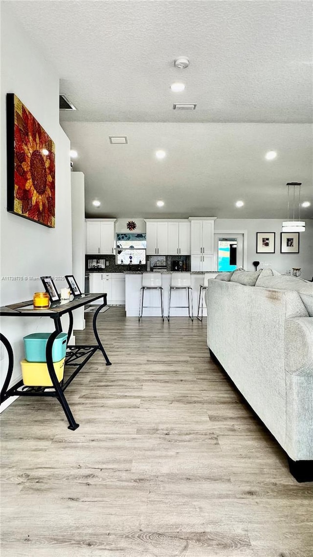 living room featuring a textured ceiling and light wood-type flooring