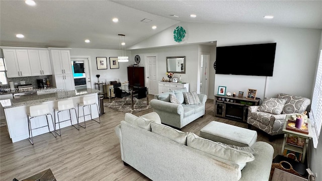 living room featuring vaulted ceiling and light hardwood / wood-style flooring