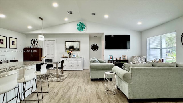 living room with vaulted ceiling and light wood-type flooring