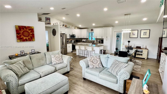 living room with vaulted ceiling and light hardwood / wood-style floors