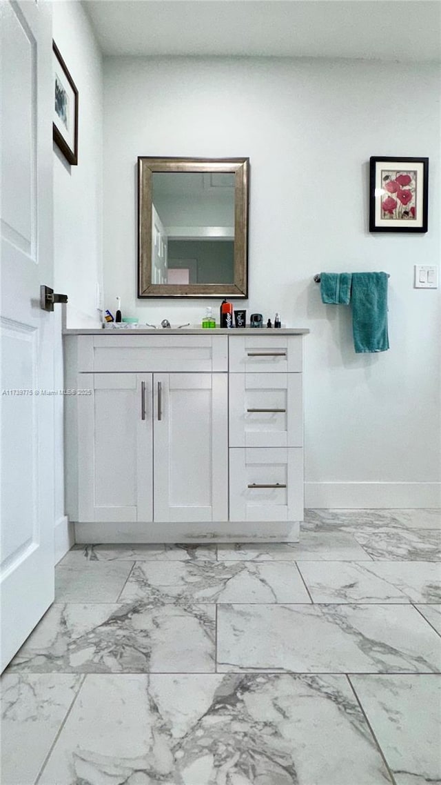 bathroom with baseboards, marble finish floor, and vanity