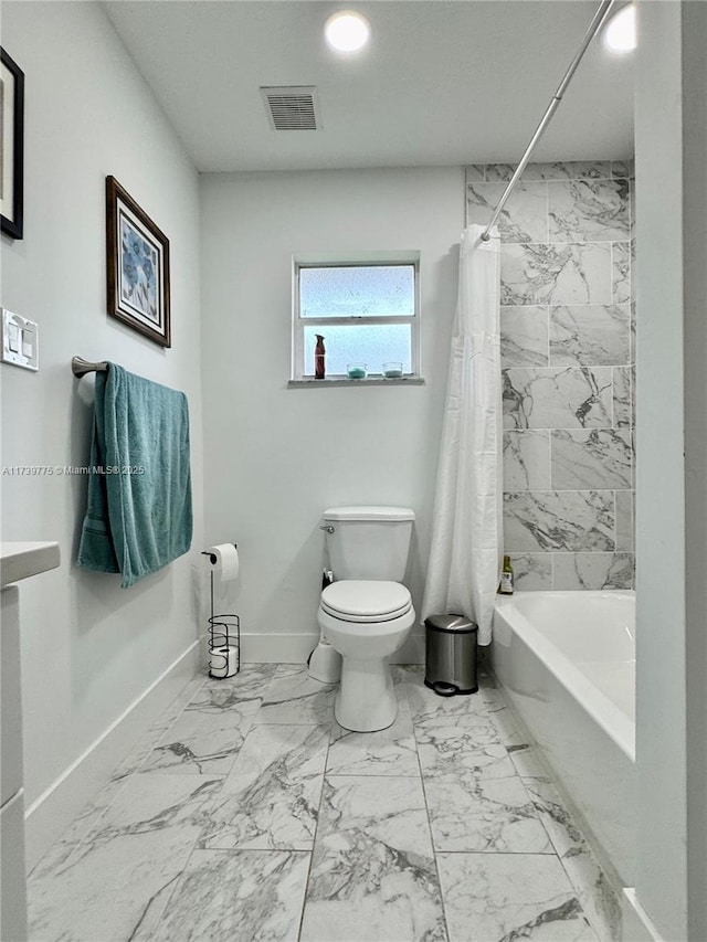 bathroom featuring shower / tub combo with curtain and toilet