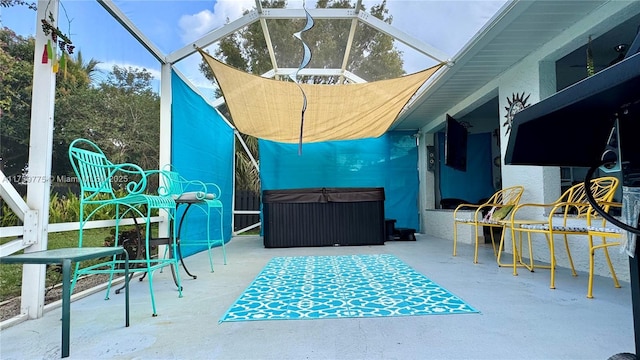 view of patio / terrace featuring a lanai and a hot tub