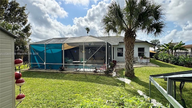 rear view of house featuring a lanai, a fenced in pool, a patio, and a lawn