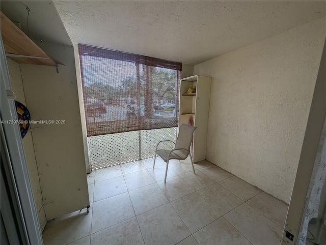 unfurnished room with a textured ceiling and light tile patterned flooring