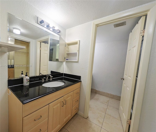 bathroom featuring tile patterned floors, a textured ceiling, and vanity