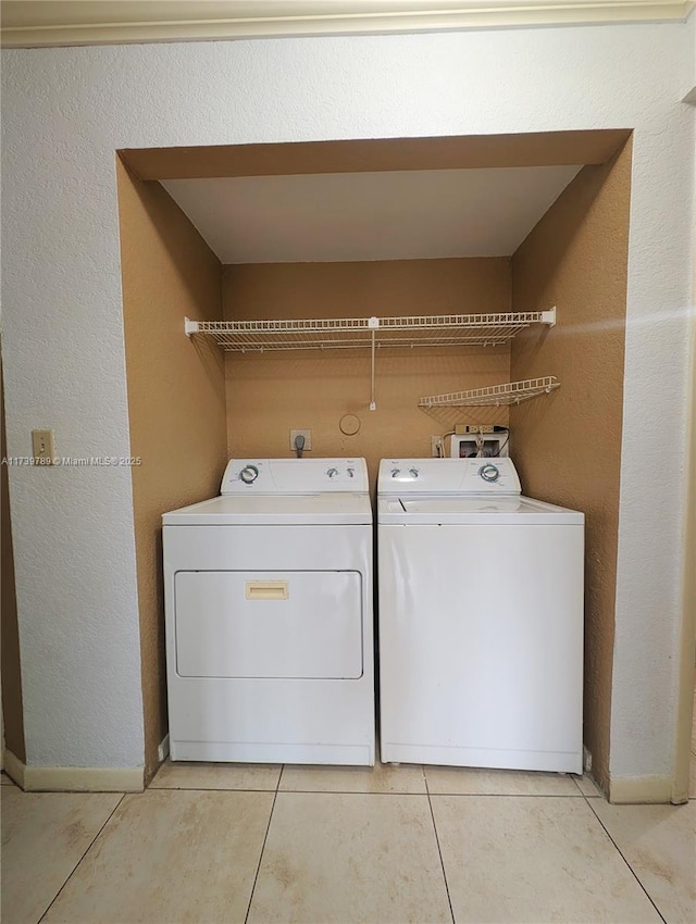 laundry area with light tile patterned floors and washer and dryer