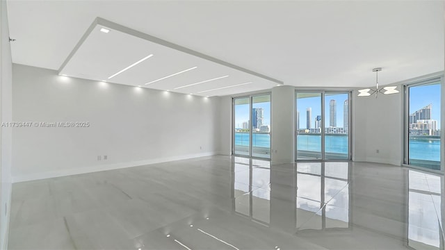 unfurnished room with baseboards, a view of city, and floor to ceiling windows