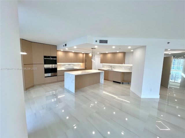 kitchen featuring a kitchen island, visible vents, a sink, and modern cabinets