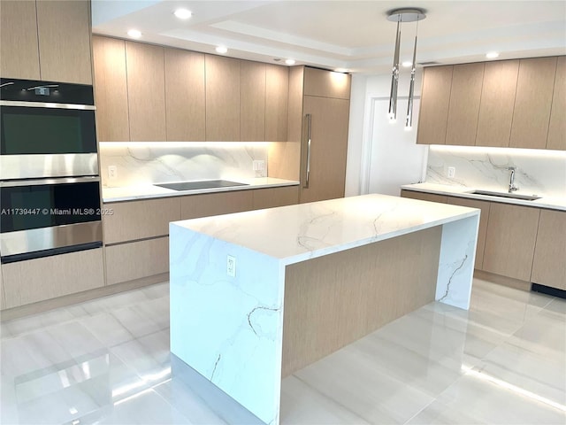 kitchen featuring modern cabinets, stainless steel double oven, and a sink