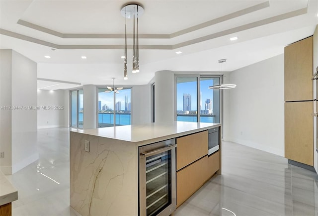 kitchen featuring beverage cooler, open floor plan, modern cabinets, and a raised ceiling