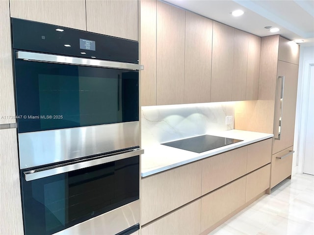 kitchen with stainless steel double oven, black electric cooktop, light countertops, decorative backsplash, and modern cabinets