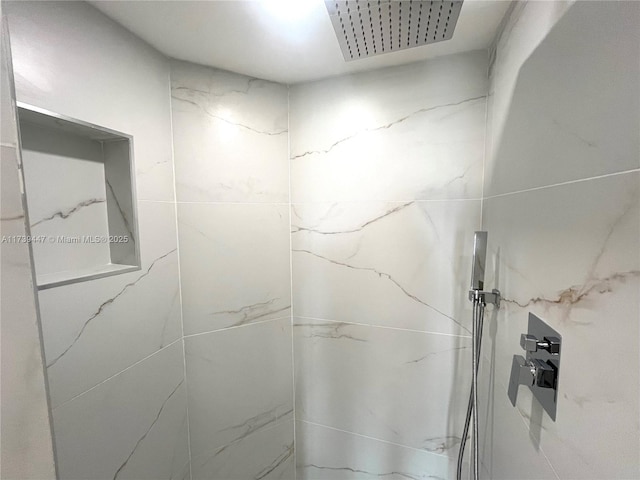 interior details featuring a marble finish shower